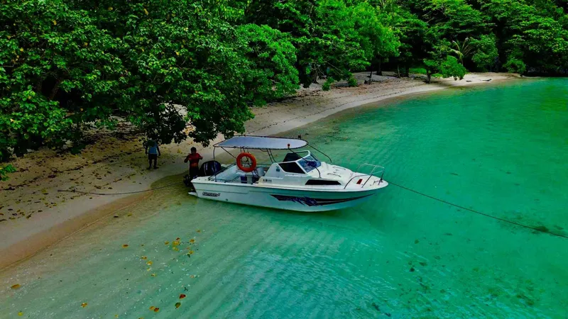 Private speedboat crossing turquoise water past karst islands on a combined Tour A and C el nido island hopping tour, Bacuit Bay, Palawan