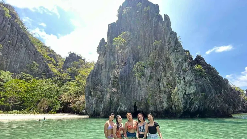 Shared bangka moored off a white sand beach during a Tour C el nido island hopping tour with buffet lunch, Bacuit Bay, Palawan